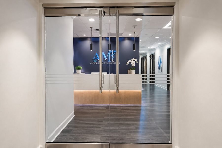 Glass entrance doors to the Aspire Medical Institute campus with branding visible in the lobby